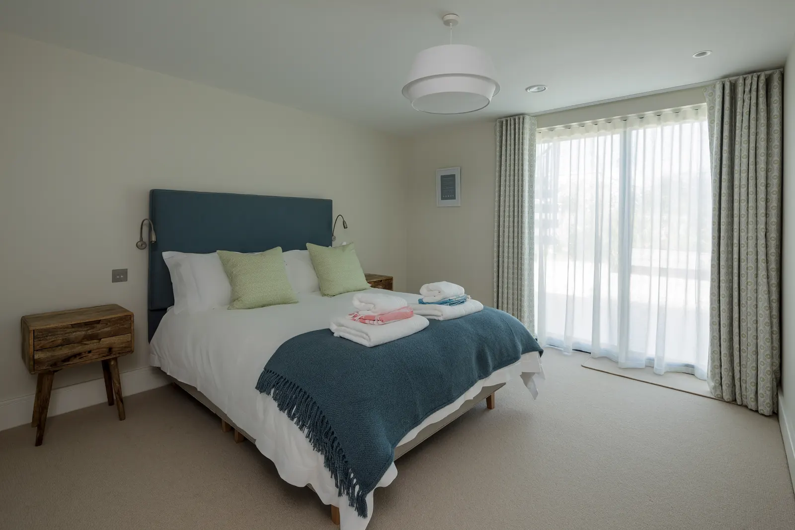 A ground-floor en-suite bedroom with a king bed and patio doors to the courtyard