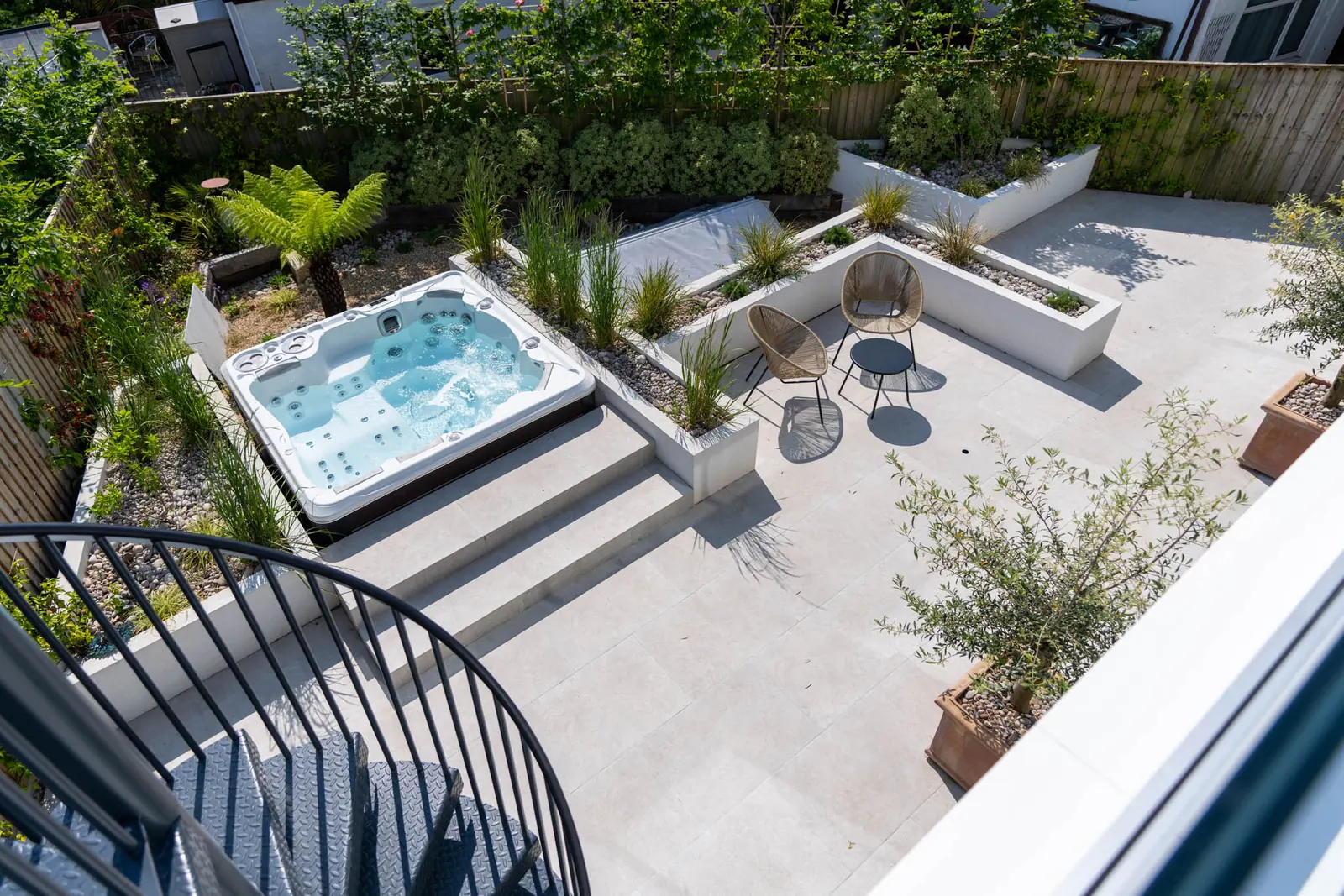 Looking down on the hot tub and courtyard from the terrace, with the spiral staircase in the foreground